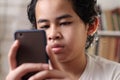 Portrait of Asian boy using his smart phone, student in library Royalty Free Stock Photo