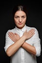 Portrait of Asian brunette woman in white shirt with arms crossed on chest on black background Royalty Free Stock Photo