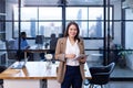 Portrait of Asian business CEO woman is standing in her office at the table with digital tablet and showing statistic chart Royalty Free Stock Photo