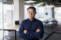 Portrait of asian businessman inside modern office, boss in glasses serious looking at camera, man with crossed arms Royalty Free Stock Photo