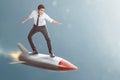 Portrait of asian businessman standing on flying rocket