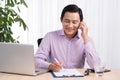 Portrait of asian businessman talking on mobile phone in office Royalty Free Stock Photo