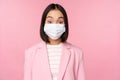 Portrait of asian businesswoman in medical face mask, wearing suit, concept of office work during covid-19 pandemic Royalty Free Stock Photo