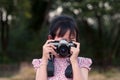 Portrait of asian cheerful little girl taking photo with film camera