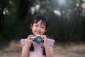 Portrait of asian cheerful little girl taking photo with film camera