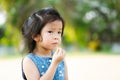 Portrait Asian child girl eating snack at outdoors. Kid hungry after playing in public park. Children is feeling hot and sweating