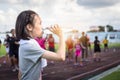 Portrait of asian child girl holding a bottle of water,drink water from a plastic bottle under the sunlight,female athlete having Royalty Free Stock Photo