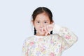 Portrait of asian child girl holding a finger up to her nose while smelling something, intolerable smell, holding breath with Royalty Free Stock Photo