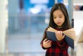 Portrait Asian child holding open textbook in hands in book store