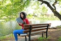 Portrait of a Asian Chinese free woman reading book in spring autumn park in forest sit on bench by a lake Royalty Free Stock Photo