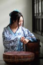 Portrait of Asian Chinese girl in traditional dress, wear blue and white porcelain style Hanfu, carry a food box in a old kitchen Royalty Free Stock Photo