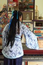 Portrait of Asian Chinese girl in traditional dress, wear blue and white porcelain style Hanfu, cook in an ancient kitchen Royalty Free Stock Photo