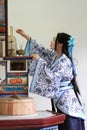 Portrait of Asian Chinese girl in traditional dress, wear blue and white porcelain style Hanfu, light candles in kitchen Royalty Free Stock Photo