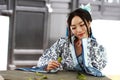 Portrait of Asian Chinese girl in traditional dress, wear blue and white porcelain style Hanfu, sit on a stone chair Royalty Free Stock Photo