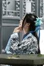 Portrait of Asian Chinese girl in traditional dress, wear blue and white porcelain style Hanfu, sit on a stone chair Royalty Free Stock Photo