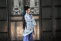 Portrait of Asian Chinese girl in traditional dress, wear blue and white porcelain style Hanfu, stand by a door Royalty Free Stock Photo