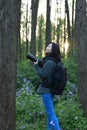 Portrait of a Asian Chinese nature woman photographer look at her camera screen in a spring park forest surround by flowers Royalty Free Stock Photo