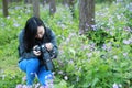 Portrait of a Asian Chinese nature woman photographer look at her camera screen in a spring park forest surround by flowers Royalty Free Stock Photo