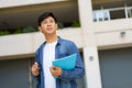 Portrait of a Asian college man student carrying a backpack and standing in a school hallway at campus Royalty Free Stock Photo