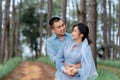 Portrait Of An Asian Couple Posing For A Pre-wedding Photo In Identical Blue Outfits, Happily Showing Off Their Expressions Of