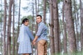 Portrait of an Asian couple posing for a pre-wedding photo in identical blue outfits, happily showing off their expressions of