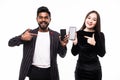 Portrait of asian couple standing and holding mobile phones pointed on screen isolated on the white background Royalty Free Stock Photo