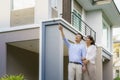 Portrait of Asian couple walking hugging and pointing together looking happy in front of their new house to start new life. Family Royalty Free Stock Photo