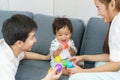 Portrait of Asian cute baby boy playing colorful plastic balls with father and mother on sofa with happy face and smiling to Royalty Free Stock Photo