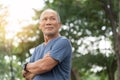 Portrait of Asian Elderly man with arms crossed relaxing over nature background. Happy confident Senior person in blue shirt Royalty Free Stock Photo