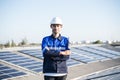 Portrait of Asian engineer on background field of photovoltaic solar panels solar cells on roof top factory.