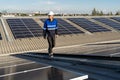 Portrait of Asian engineer on background field of photovoltaic solar panels solar cells on roof top factory.