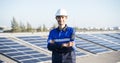 Portrait of Asian engineer on background field of photovoltaic solar panels solar cells on roof top factory.