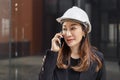 Portrait, asian engineer developer woman wear black suit and white safety hardhat calling with mobile phone. Royalty Free Stock Photo