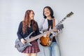 Portrait of Asian family duo rock band of young girl idol on bassist and male on semi hollow electric guitar standing on white Royalty Free Stock Photo