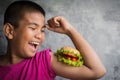 Portrait Asian fat boy enjoy eating with hamburger