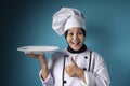 Asian Female Chef Shows Empty White Plate, Presenting Something, Copy Space Royalty Free Stock Photo