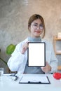 Portrait of asian female doctor holding mock up digital tablet and smiling to camera. Blank screen for your advertising text Royalty Free Stock Photo