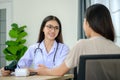 Portrait of Asian female doctor measuring heart and blood pressure while taking care of beautiful asian patient in medical Royalty Free Stock Photo