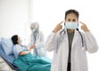 Portrait of Asian female doctor wearing protective mask on background of Asian female muslim doctor taking care of patient in hosp