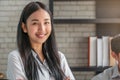 Portrait of Asian female student with bookshelf in library Royalty Free Stock Photo