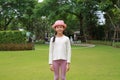 Portrait of Asian girl child wear a pink straw hat and standing with looking camera in the garden Royalty Free Stock Photo