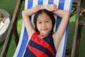 Portrait of Asian girl kid in swimsuit with wet hair lying on canvas bed near the pool Royalty Free Stock Photo