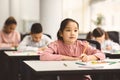 Portrait of asian girl sitting in classroom and writing Royalty Free Stock Photo