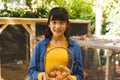 ortrait of asian girl smiling and holding basket, collecting eggs from hen house in garden