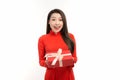 Portrait of an Asian girl in a traditional Vietnamese dress, ao dai, a good smile, holding gift box Royalty Free Stock Photo