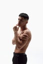 Portrait of asian handsome young man posing shirtless in trousers against white studio background. Spotless face Royalty Free Stock Photo