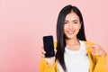 Portrait Asian happy beautiful young woman smile making finger pointing on smartphone in hand shopping online application Royalty Free Stock Photo