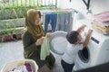 happy mother and son doing laundry together Royalty Free Stock Photo