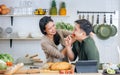 Portrait Asian happy young adult couple lover helping together, holding kitchenware, cooking in cozy home kitchen in morning, Royalty Free Stock Photo