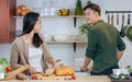 Portrait Asian happy young adult couple lover helping together, holding kitchenware, cooking in cozy home kitchen in morning, Royalty Free Stock Photo